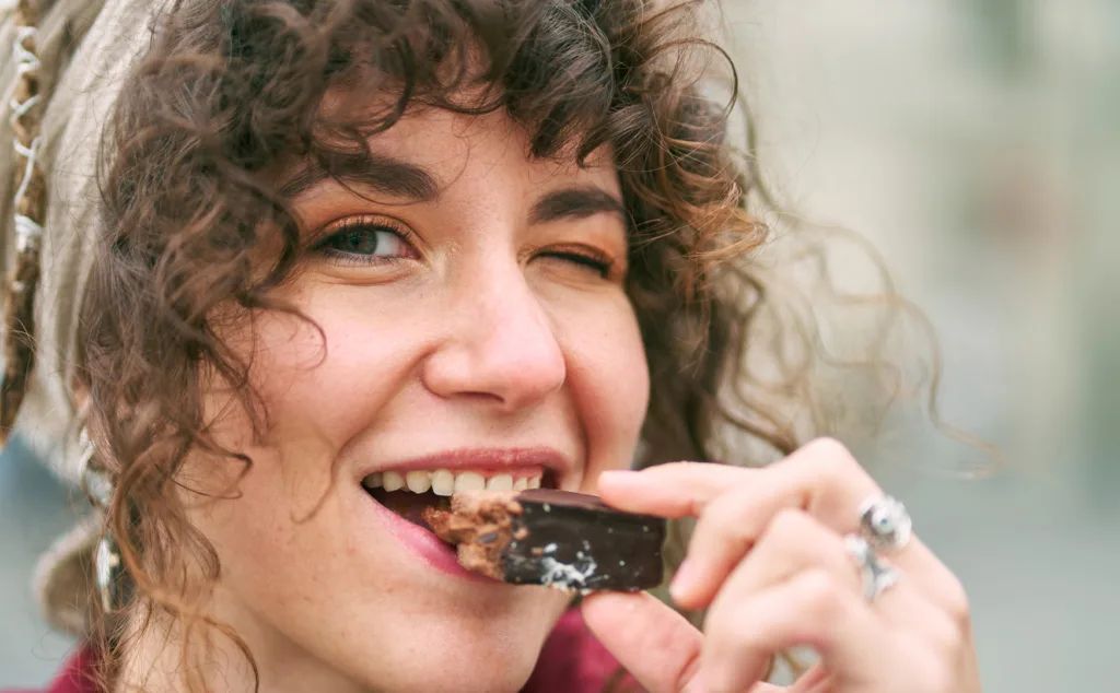 Portrait of happy woman eating chocolate