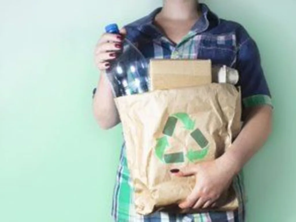 Woman holding a recycling bag filled with packing material to be recycled